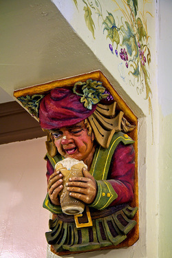 Detail of wall corner piece of man drinking a beer